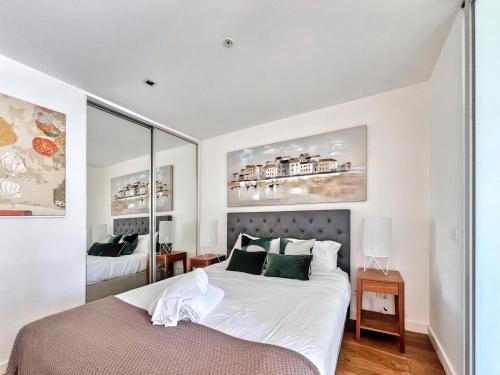 a bedroom with a large white bed with green pillows at Beautiful 1B1B Prahran apartment in Melbourne