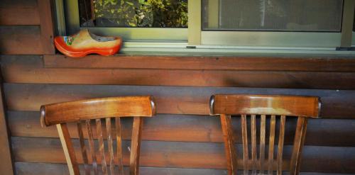 two wooden chairs sitting in front of a window at Cabin Resort in Moshav Ramot