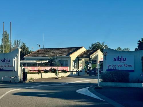 a couple of signs in front of a building at Joli Bungalow 464 pour 4-6 pers Camping Siblu Lac des Rêves Lattes in Pérols
