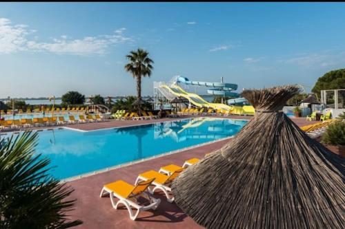 a resort with a pool with chairs and a slide at Joli Bungalow 464 pour 4-6 pers Camping Siblu Lac des Rêves Lattes in Pérols