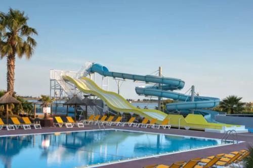 a water slide at a resort with a swimming pool at Joli Bungalow 464 pour 4-6 pers Camping Siblu Lac des Rêves Lattes in Pérols