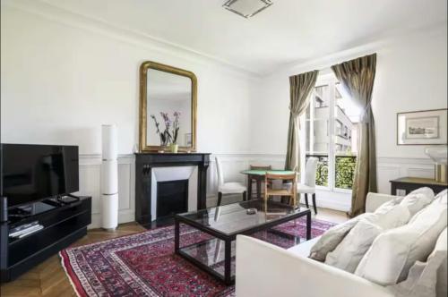 un salon avec un canapé blanc et une cheminée dans l'établissement Appartement proche île saint Louis, à Paris