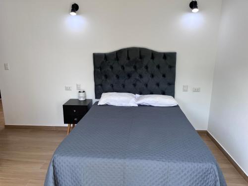 a bedroom with a large bed with a black headboard at Casa de Campo VIP San Andrés in San Andrés
