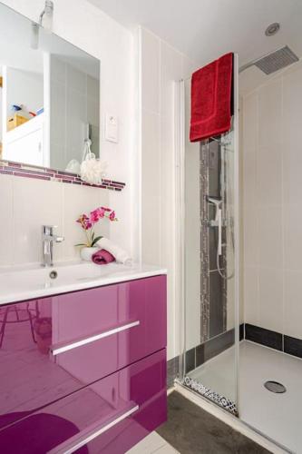 La salle de bains est pourvue d'un lavabo violet et d'une douche. dans l'établissement Petit village au calme, à Chadeleuf