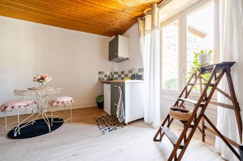 - une cuisine avec une échelle dans une chambre avec une table dans l'établissement Petit village au calme, à Chadeleuf