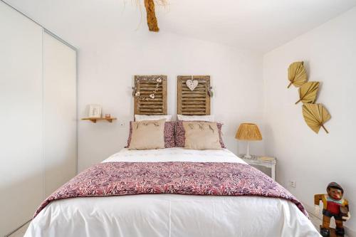 une chambre avec un grand lit avec des draps blancs dans l'établissement Petit village au calme, à Chadeleuf