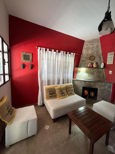 a living room with a red wall with a fireplace at Casa Familiar Villa Carlos Paz in Villa Carlos Paz
