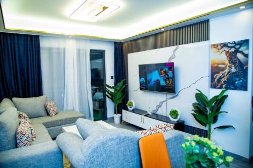 a living room with two couches and a tv at Luxury modern Apartment in Nairobi
