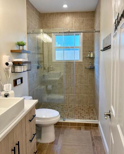 a bathroom with a toilet and a glass shower at Saugerties Waterfront Getaway in Saugerties
