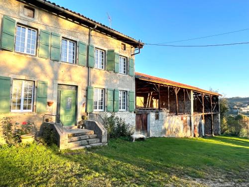 an old house with a green door on a yard at Domaine de Montfort in Saint-Lizier