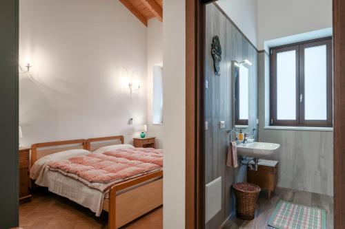 a bedroom with a bed and a sink and a bathroom at Agriturismo Cascina Tavolette in Pralboino