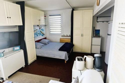 Cette petite chambre comprend un lit et une télévision. dans l'établissement Appartement le Barcares vue mer, au Barcarès