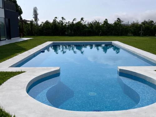 a swimming pool with blue water in a yard at Casa de Campo VIP San Andrés in San Andrés