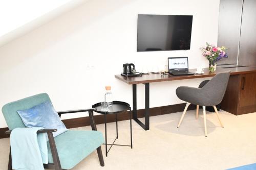 a room with a desk with a laptop and chairs at MedHotel Smart Krupnicza w Krakowie in Kraków