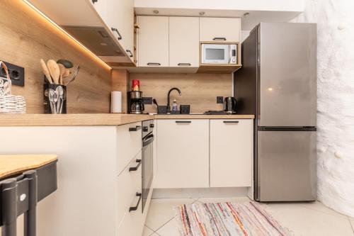 a kitchen with white cabinets and a stainless steel refrigerator at Guest house Otto in Punat
