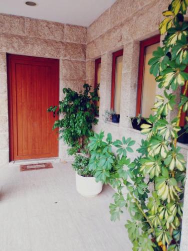 a building with a red door and potted plants at Casa da Vinha in Santa Eulália