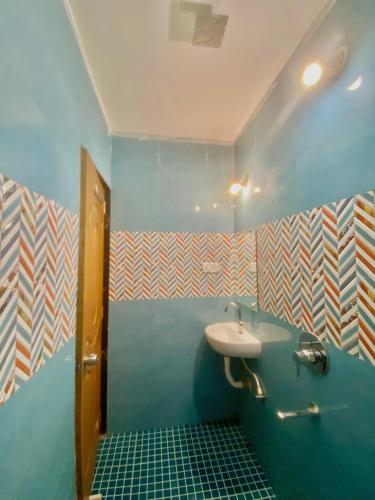 a bathroom with a sink and a blue wall at Coconut Inn - Parra Goa in Mapusa