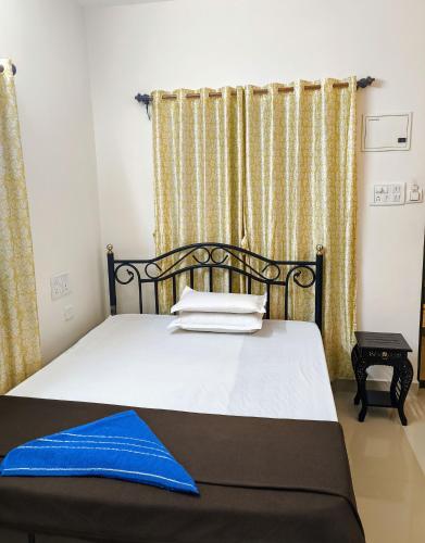 a bedroom with a bed with a blue blanket on it at Coconut Inn - Parra Goa in Mapusa