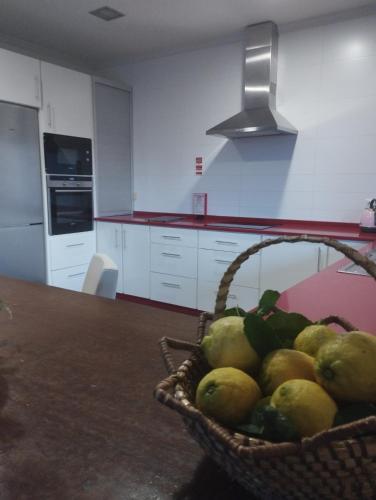 a basket of fruit on a table in a kitchen at Casa da Vinha in Santa Eulália