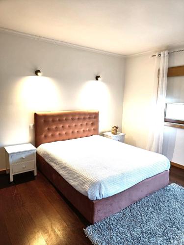 a bedroom with a large bed and a blue rug at Casa da Vinha in Santa Eulália