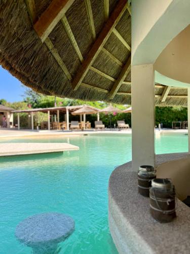 - une piscine d'eau bleue dans un complexe dans l'établissement Nino Lodge, à Samba Dia
