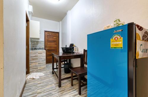 a kitchen with a table and a blue refrigerator at The Bulin Residence in Lamai