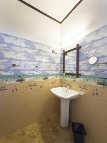 a bathroom with a sink and a painting on the wall at Mount Seven Holiday Inn in Belihul Oya