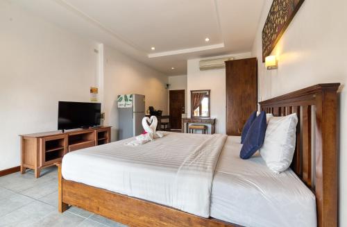 a bedroom with a large bed and a television at The Bulin Residence in Lamai