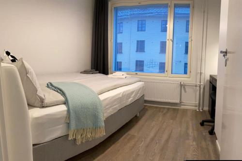 una camera da letto con un letto e una grande finestra di Modern apartment with sauna, balcony and parking A17 a Turku