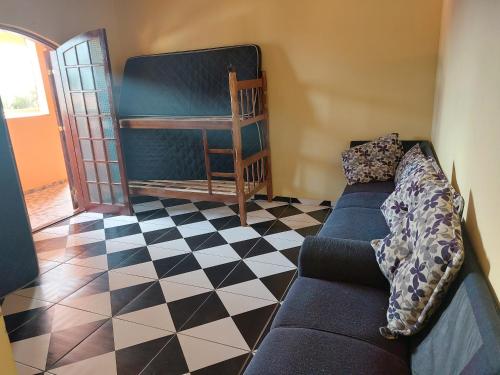 een woonkamer met een bank en een wieg bij Casabelamare Itanhaém in Itanhaém