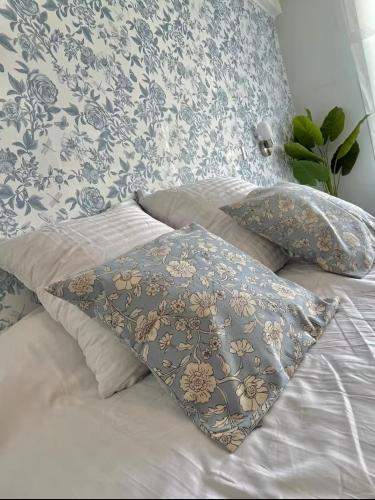 un lit avec des oreillers bleus et blancs dessus dans l'établissement La loge de Gustave, studio avec wifi, à Mont-de-Marsan