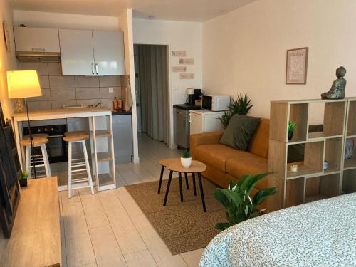 un salon et une cuisine avec un canapé et une table dans l'établissement Studio Casa Cosy, à Saint-Laurent-du-Var