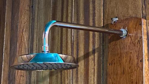 a shower head hanging on a wooden wall at Amaca Eco Station in Iquitos