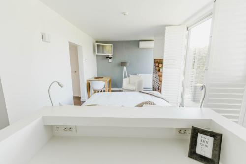 a white bedroom with a bed and a window at B&B Villa Tartine in Puurs