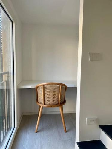 a wicker chair sitting next to a desk in a room at Luminoso, appena ristrutturato in Santa Margherita Ligure