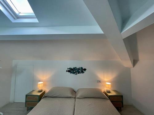 a bedroom with two beds and a skylight at Luminoso, appena ristrutturato in Santa Margherita Ligure