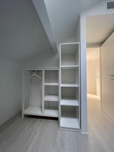 a white closet with shelves in a room at Luminoso, appena ristrutturato in Santa Margherita Ligure