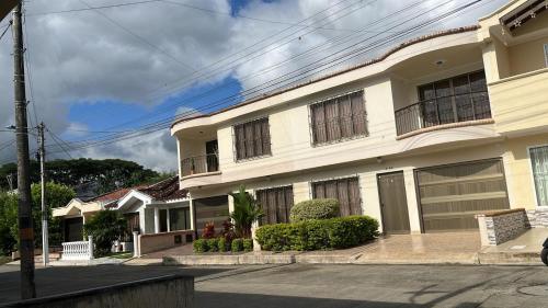a large white building with windows on a street at Guesthouse Nomad7 in Roldanillo