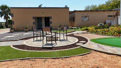 a patio with chairs and a table in front of a building at Kebo events agro &self catering apartments in Mochudi