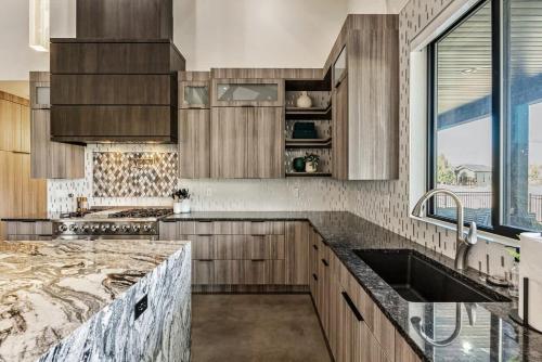 a kitchen with wooden cabinets and a sink and a window at Hot Tub Minutes 2 ParkCity & Jodanelle Pets are Allowed in Francis