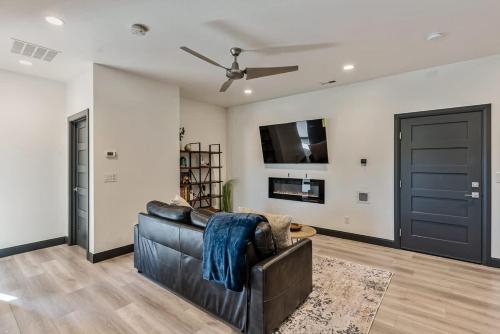 a living room with a leather couch and a tv at Hot Tub Minutes 2 ParkCity & Jodanelle Pets are Allowed in Francis