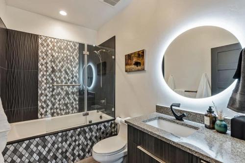 a bathroom with a sink and a toilet and a mirror at Hot Tub Minutes 2 ParkCity & Jodanelle Pets are Allowed in Francis