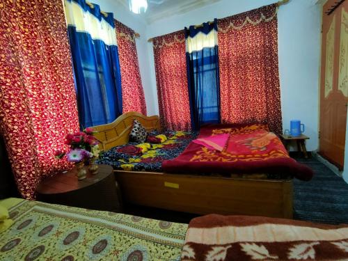 a bedroom with a bed and curtains and a table at Kashmir naaz in Srinagar