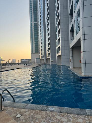 a swimming pool on the roof of a building with tall buildings at Ocean View Luxurious Homes in Ajman 