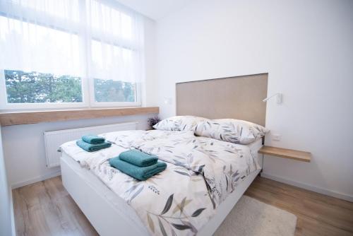 a bedroom with a bed with green towels on it at Apartmán Dominanta in Liptovský Mikuláš
