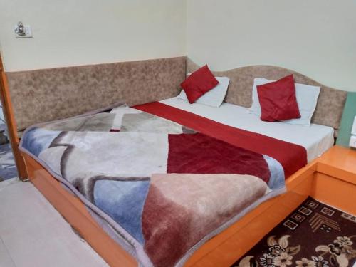 a bed with two blankets and pillows on it at Hotel Amar palace pachmarhi in Pachmarhī