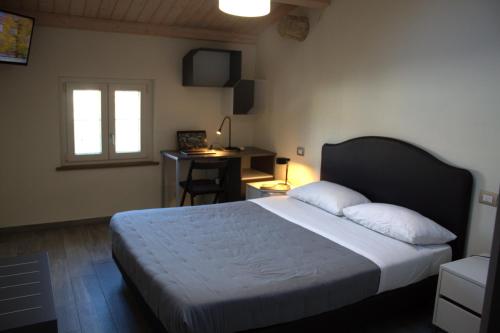 a bedroom with a bed and a desk and a window at Locazione Turistica Rania in Lucca