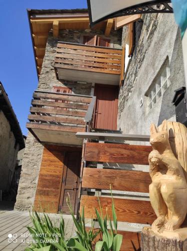 a building with wooden stairs and a cat statue at Orobie Holiday Apartments in Albosaggia