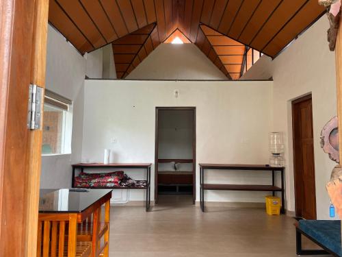 a living room with a wooden ceiling and a table at Senthamarai homestay in Sultan Bathery