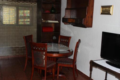 a dining room with a table and chairs and a television at Apartments Mijuskovic in Donji Morinj